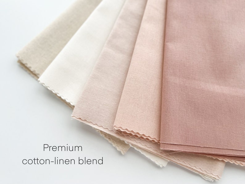 May include: A close-up of five fabric swatches in various shades of beige and pink. The swatches are arranged in a fan shape and have a slightly textured surface. The text "Premium cotton-linen blend" is printed below the swatches.