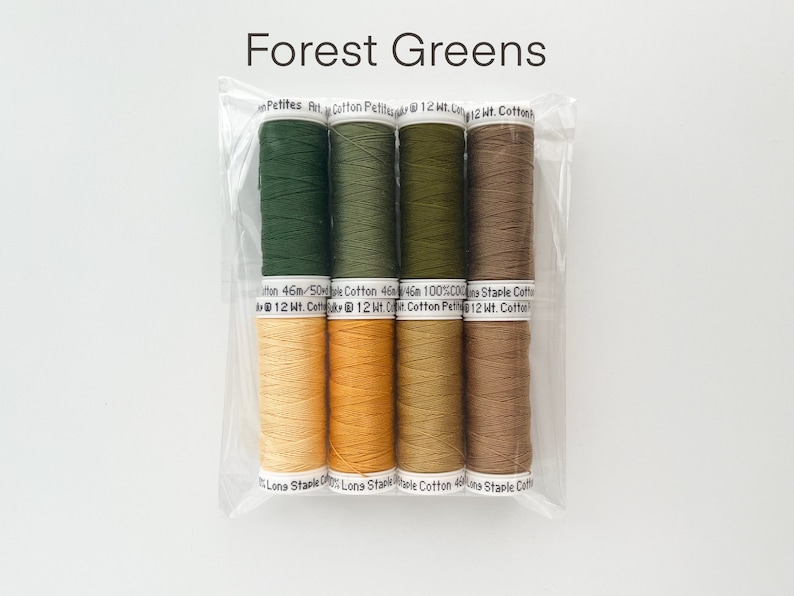 May include: A package of six spools of thread in shades of green and brown. The spools are labeled "Petites Pit Cotton Petite 12 Wt. Cotton" and "Long Staple Cotton 46m/50m 100% Cotton 12 Wt. Cotton".