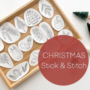 May include: A wooden tray contains white fabric patches with black line drawings of Christmas designs, such as a sweater, tree, and reindeer. The text "CHRISTMAS Stick & Stitch" is in a red circle.