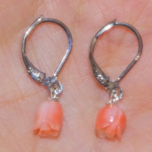 Peut inclure: Une paire de boucles d'oreilles en argent avec des pendentifs en forme de fleur de corail rose.