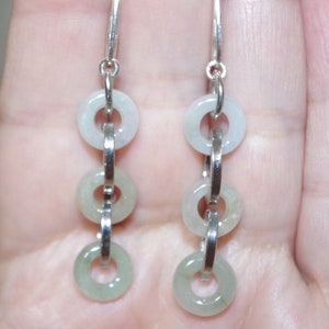 May include: Silver dangle earrings with three jade green rings on each earring.
