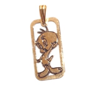 Op de afbeelding: Goudkleurige hanger met een uitgesneden ontwerp van Tweety Bird. De hanger heeft een rechthoekige vorm met een lus voor een ketting. Het stripfiguur wordt afgebeeld in een staande pose.