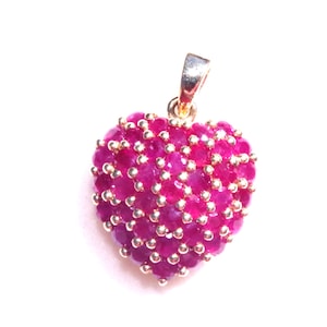 May include: A heart-shaped pendant made of gold and set with ruby stones.