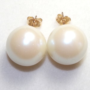 May include: A pair of white pearl earrings with gold posts.