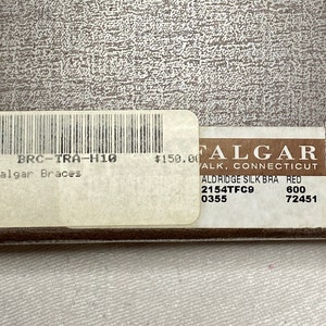 May include: A close-up of a product tag with the text "Trafalgar Braces" and "ALDRIDGE SILK BRA RED". The tag also includes a barcode and the price of $150.00.