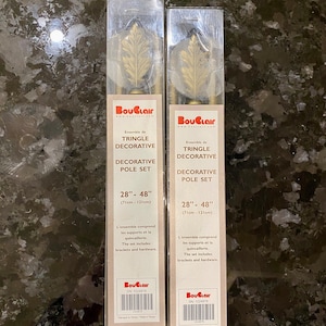 May include: Two decorative curtain pole sets. Each set includes a gold-colored pole, leaf-shaped finials, and mounting hardware. The packaging displays the brand name "BouClair" and the text "Decorative Pole Set 28" - 48" (71cm - 121cm)."