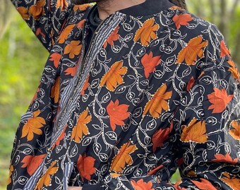 May include: A black bomber jacket with a floral pattern in orange and white. The jacket has a zipper closure and a ribbed collar, cuffs, and waistband.