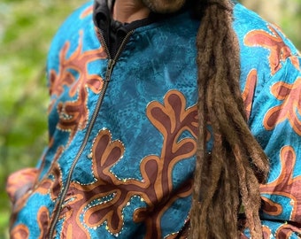 May include: A blue and brown patterned bomber jacket with a zipper closure. The jacket has a unique design with brown leaf-like shapes on a blue background.