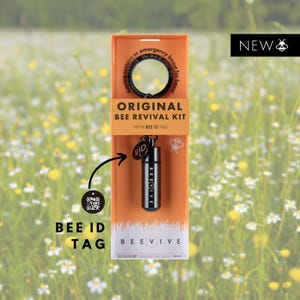 Peut inclure: Un porte-clés noir avec une petite fiole contenant un kit de réanimation d'abeilles d'urgence. Le porte-clés a une étiquette d'identification d'abeille avec un code QR. L'emballage est orange et indique "Kit de réanimation d'abeilles original avec étiquette d'identification d'abeille".