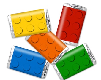 May include: Five small chocolate bars wrapped in silver foil with colorful printed designs resembling Lego bricks. The colors are yellow, red, orange, blue, and green.