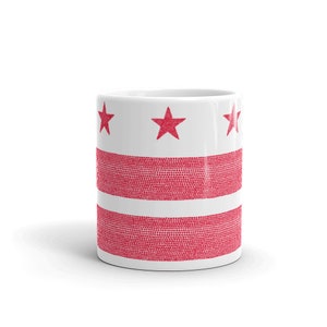 Könnte beinhalten: Weiße Keramiktasse mit einem roten und weißen Design der Flagge des District of Columbia. Die Flagge zeigt drei rote Sterne und drei rote Streifen.