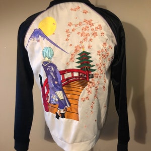 May include: Black satin bomber jacket with a white satin back panel featuring an embroidered scene of a woman in a kimono walking across a red bridge with a pagoda and cherry blossoms in the background.