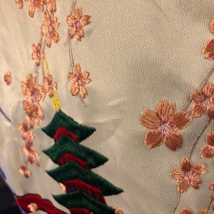 May include: White fabric with embroidered pink cherry blossoms and a red and green pagoda.