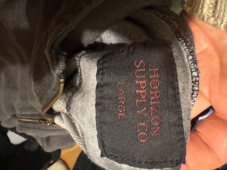 May include: A gray hooded sweatshirt with a black tag that reads "Horizon Supply Co." and "Large" in red lettering.
