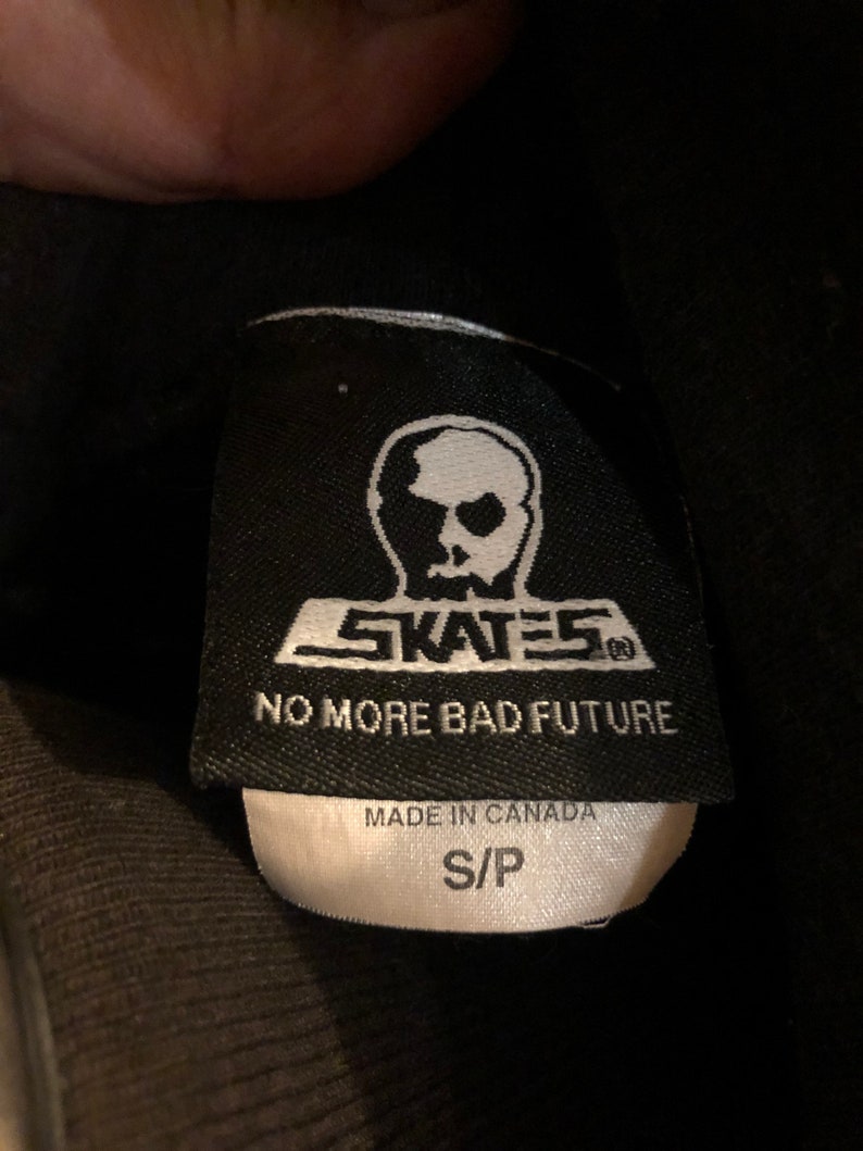 May include: Black and white label with a skull logo and the text "SKATES" and "NO MORE BAD FUTURE". The label also says "MADE IN CANADA" and "S/P".