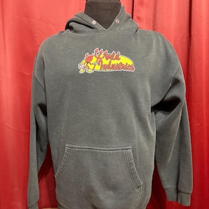 May include: Dark gray hoodie with a kangaroo pocket and a drawstring hood. The front features a graphic of a cartoon character and the words "World Industries" in yellow and red. The hoodie is displayed on a mannequin.