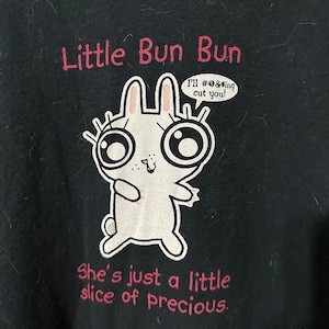 May include: Black t-shirt featuring a cartoon bunny with large eyes and a speech bubble saying "I'll #@&ing cut you!". The text "Little Bun Bun" and "She's just a little slice of precious" are printed in pink on the shirt.