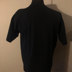 May include: A black short-sleeved t-shirt on a mannequin.