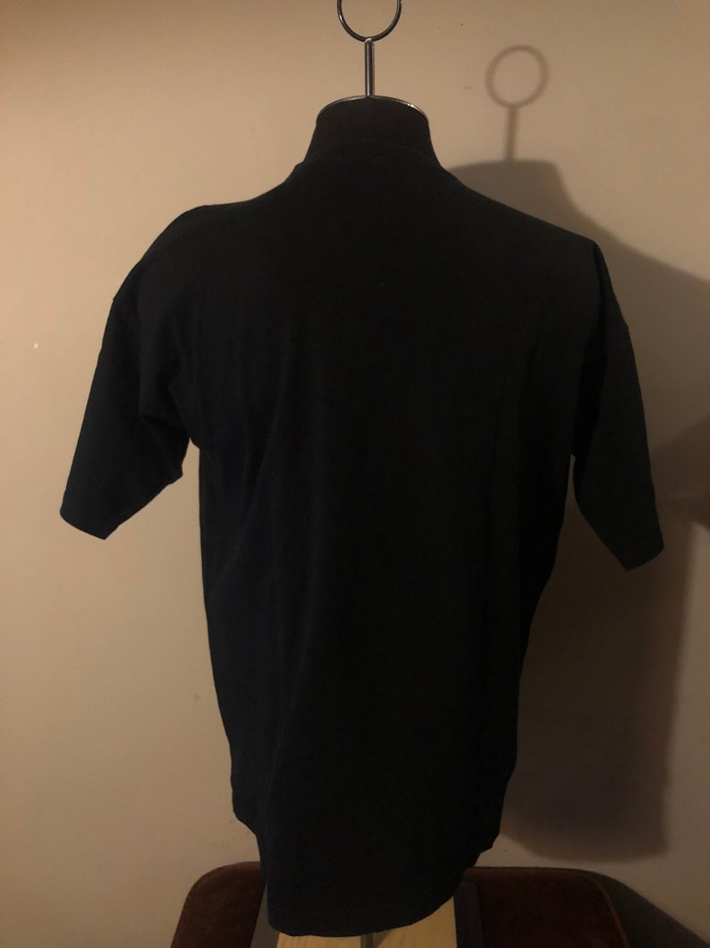 May include: A black short-sleeved t-shirt on a mannequin.