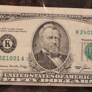 May include: A fifty dollar bill featuring Ulysses S. Grant, the 18th President of the United States. The bill is from Series 1966 and has the serial number K24021001 A. The bill is in good condition and has a green seal.
