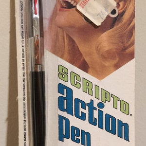 Może przedstawiać: Czarno-srebrny długopis Scripto Action z czerwonym przyciskiem z boku. Opakowanie przedstawia uśmiechniętą kobietę i tekst "Scripto Action Pen" w niebieskich i zielonych literach. Tekst "Turn it on" i "Turn it off" jest w czerwonych i czarnych literach. Opakowanie zawiera również tekst "Ten długopis kulkowy Scripto charakteryzuje się pozytywnym działaniem dwóch przycisków i nawilżonym atramentem, zapewniającym łatwe pisanie. Przezroczysty wkład pozwala wiedzieć, kiedy atrament się kończy."