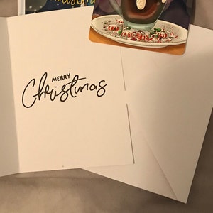 May include: A white card with the words "Merry Christmas" written in black cursive.