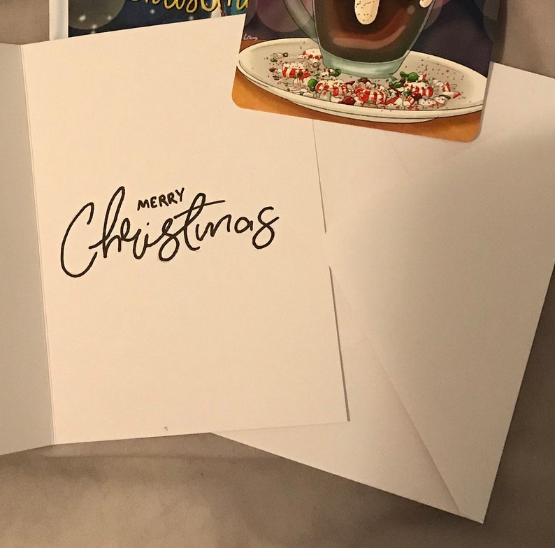 May include: A white card with the words "Merry Christmas" written in black cursive.