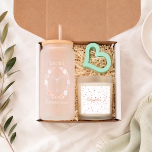 Peut inclure: Un coffret cadeau contenant un gobelet en verre dépoli avec couvercle en bambou et paille, orné d'un motif de livre et de roses avec le texte Lost in a Romance novel, un objet vert menthe en forme de cœur et une bougie étiquetée Chapter 1.
