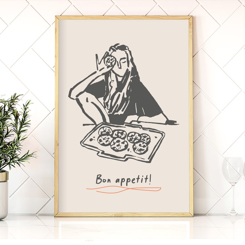 May include: A black and white illustration of a person holding a cookie in front of their eye. The person is sitting at a table with a tray of cookies in front of them. The text "Bon appetit!" is written below the tray.
