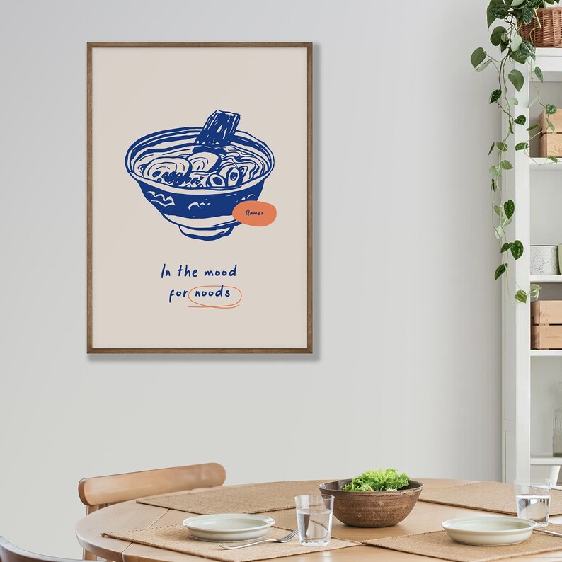 May include: A framed illustration of a bowl of ramen noodles with the text "Ramen" and "In the mood for noodles" in a blue and orange color scheme.