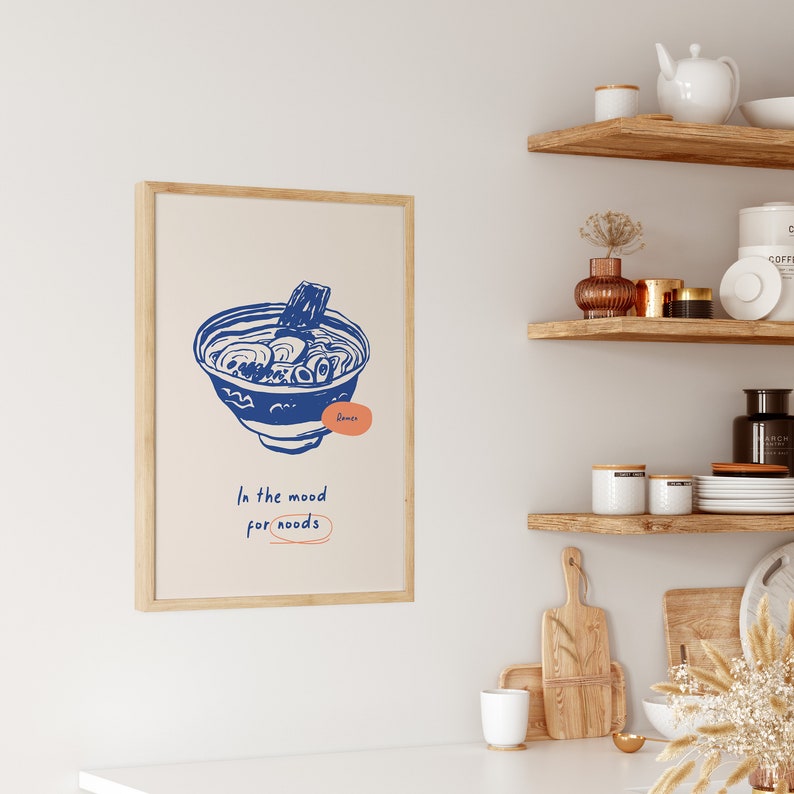 May include: A framed print with a blue illustration of a bowl of ramen noodles. The text "In the mood for noodles" is written below the illustration.
