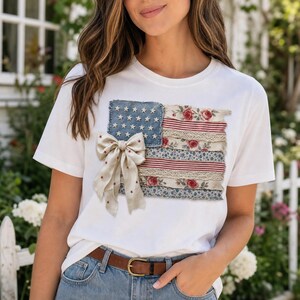 Peut inclure: T-shirt blanc avec un motif de drapeau américain patriotique. Le drapeau est fait de denim, de tissu floral et rayé, avec un nœud. Le motif du drapeau comprend des étoiles, des rayures et des accents floraux, créant un look unique et élégant.