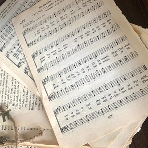 May include: A close-up of a stack of vintage sheet music with the title "Give Me, O Lord, A Shelter" and the lyrics "Let faith make all my conduct, Thy will be all my law." The music is printed in black ink on white paper.