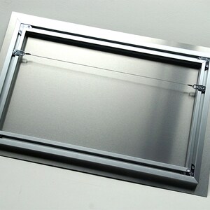 May include: A rectangular metal print with a silver frame and a wire hanging system. The back of the print is a brushed silver color. The frame is made of aluminum and has a black border.