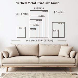 May include: A beige sofa with two pillows is positioned below a wall displaying a vertical metal print size guide. The guide shows various print sizes in inches, including 24x36, 20x30, 16x24, 12x18, 11x14, 8x12, 16x20, and 8x10.