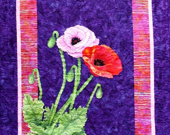 May include: A quilted wall hanging with a floral design. The central image shows two poppies, one pink and one red, with green stems and leaves, set against a purple background. The quilt has a purple border with a pink and orange inner frame.