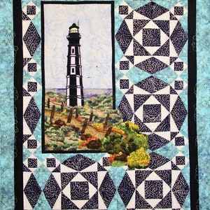 Pode incluir: Uma colcha preta e branca com um padrão geométrico. O centro da colcha apresenta uma imagem de um farol numa praia.