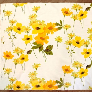 Könnte beinhalten: Weißer Stoff mit einem sich wiederholenden Muster aus gelben Blumen und grünen Blättern. Die Blumen sind in verschiedenen Größen und Formen gehalten, mit einer Mischung aus offenen und geschlossenen Blüten. Der Stoff hat Text am Rand.