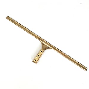 May include: A gold-colored window squeegee with a T-shaped handle. The squeegee blade is long and straight.