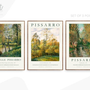 May include: Set of three art prints featuring paintings by Camille Pissarro. Each print features a landscape scene with a river and trees. The prints are framed in a simple brown frame with a white mat.