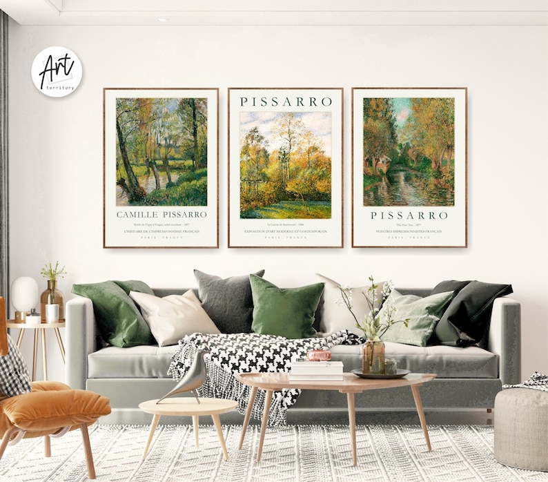 May include: Three framed art prints of landscape paintings by Camille Pissarro. The prints feature a river flowing through a forest with trees in various shades of green and yellow. The prints are titled "Camille Pissarro", "Pissarro", and "Pissarro".