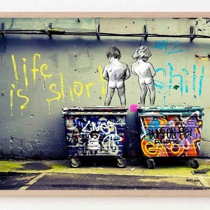 May include: A graffiti-covered wall with the text "life is short chill this out" in yellow and blue paint. Two figures are painted on the wall, one in front of a blue dumpster and the other in front of a purple dumpster. The dumpsters are covered in graffiti.