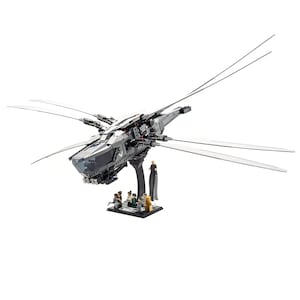 Puede incluir: Una nave espacial gris y negra con cuatro brazos largos y delgados, construida con ladrillos Lego. La nave espacial está en un soporte negro con un grupo de minifiguras de pie frente a ella.