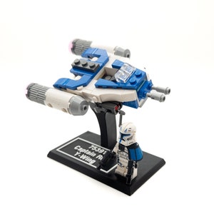 Puede incluir: Set de construcción LEGO Star Wars 75391 Caza Estelar Y-Wing del Capitán Rex con una nave espacial Y-Wing azul y blanca y una minifigura del Capitán Rex. El set incluye un soporte de exhibición con el texto "75391 Captain Rex's Y-Wing".