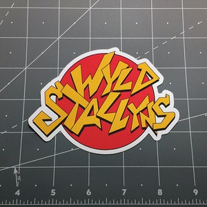 May include: A red and yellow sticker with the words "WYLDE STALLINS" in a stylized font.