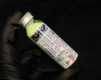 May include: A small glass vial with a silver cap, filled with a pale yellow liquid. The vial has a label with the text "GENETIC RESEARCH SPECIMEN" and other scientific details. The vial is held against a black background.