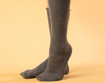 May include: A pair of grey ribbed socks with a folded cuff. The socks are made of a soft, comfortable material.