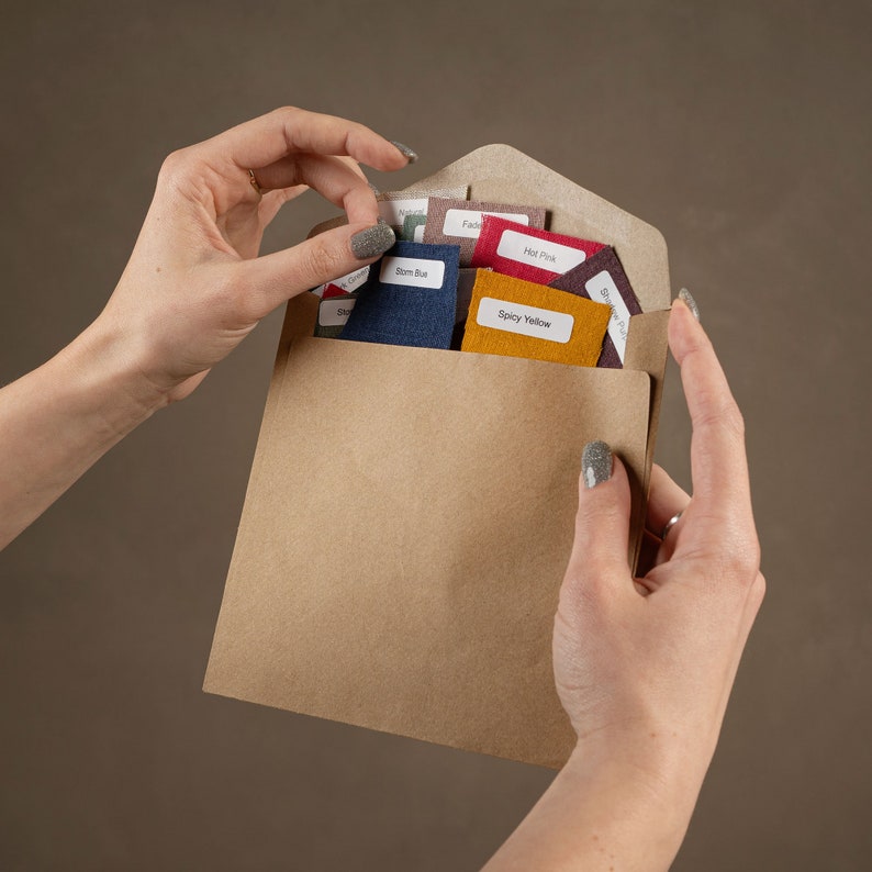 May include: A brown paper envelope with a variety of fabric swatches inside. The swatches are labeled with names like "Spicy Yellow", "Hot Pink", and "Storm Blue".