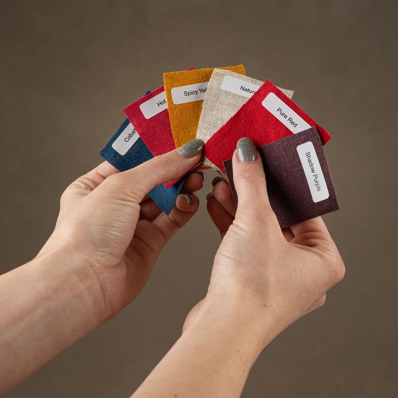 May include: A set of fabric swatches in various colors, including cobalt, hot red, spicy yellow, natural, pure red, and shadow purple. Each swatch has a label with the color name.