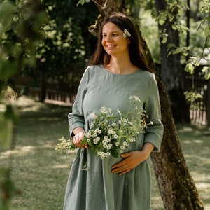 In the photograph the model is wearing the maternity dress LUCY in mint green color. The round neckline compliments the neck.